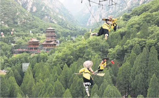  ?? Picture: Reuters ?? Shaolin martial arts students perform kung fu suspended on wires in a rehearsal for an action show in Zhengzhou, Henan province, China on Saturday.