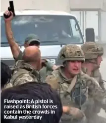  ??  ?? Flashpoint: A pistol is raised as British forces contain the crowds in Kabul yesterday