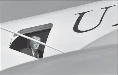  ?? The Associated PRess ?? TRUMP: President Donald Trump steps through the door of Air Force One on Friday at Morristown Municipal Airport in Morristown, N.J.. Trump is spending the weekend in Bedminster, N.J., at his golf club.