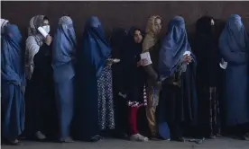  ?? Photograph: Petros Giannakour­is/AP ?? Women queue to receive cash at a distributi­on point organised by the World Food Programme in Kabul on 20 November.