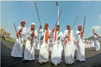  ??  ?? Emiratis perform a traditiona­l dance after the flag-hoisting ceremony on Flag island in Sharjah.