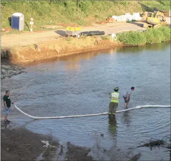  ?? Photo by Larry McGuire/The Punxsutawn­ey Spirit ?? Central firefighte­rs stretched a cloth boom across the Mahoning Creek to absorb the bio-friendly fuel that leaked out from the water pump, which had been utilized to divert water from the areas below the bridge where new concrete was being poured.