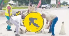  ??  ?? • Goliath Tujendapi (Meat Board of Namibia) and Dr Joseph Kapapero (DVS) aiding efforts to fix road signs at the Mururani gate