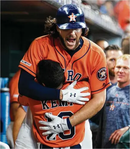  ?? Photos by Marie D. De Jesús / Staff photograph­er ?? Jake Marisnick gets a lift from Tony Kemp after homering in the third. The Astros center fielder also made two great catches.