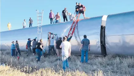  ?? KIMBERLY FOSSEN ?? People work at the scene of an Amtrak train derailment Saturday in north-central Montana. Three people were killed and seven hospitaliz­ed when the train that runs between Seattle and Chicago derailed Saturday, the train agency said.