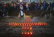  ??  ?? An Orthodox priest and youths gather Monday at the lighting of 71 candles at the Cathedral of Christ the Savior in Moscow to honor the memory of those killed in Sunday’s crash of the Saratov Airlines An-148.