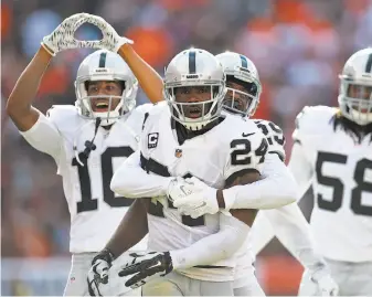  ?? Jason Miller / Getty Images ?? Charles Woodson (24) sealed the Raiders’ victory with an intercepti­on in the final minute. The turnover was part of a day in which the defense had a fumble recovery and five sacks.