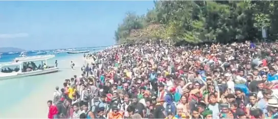  ??  ?? LEFT People crowd on the shore as they attempt to leave the Gili Islands after an earthquake in Lombok, Indonesia yesterday.