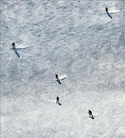  ?? Pam Panchak/Post-Gazette ?? Skiers make their way down a slope at Seven Springs Mountain Resort on Friday in Somerset County.