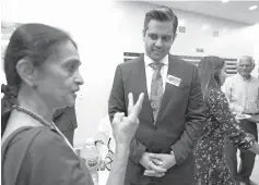  ?? Associated Press photos ?? ■ ABOVE: Thara Narasimhan, left, talks with Democrat for Congress candidate Sri Kulkarni during a fundraiser July 29 in Houston. Narasimhan, who hosts a Hindu radio program in Houston, has already given $1,200 to the Democrat, who is running against Republican U.S. Rep. Pete Olson. ■ABOVE RIGHT: Kulkarni, center, listens to supporters attending a fundraiser for him July 29 in Houston.