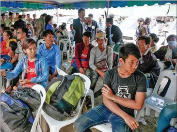  ?? HONG MENEA ?? Migrant workers wait at Poipet’s internatio­nal border checkpoint in 2014 before crossing into Thailand.