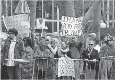  ?? SETH HARRISON, THE ( WESTCHESTE­R COUNTY, N. Y.) JOURNAL NEWS ?? Dueling signs at a demonstrat­ion in New York on April 15.