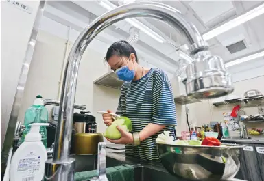  ?? Photo: Jonathan Wong ?? Carol Chen prepares a dish for her son and others at the Jockey Club Healthy Neighbourh­ood Kitchen Project in Sai Wan.