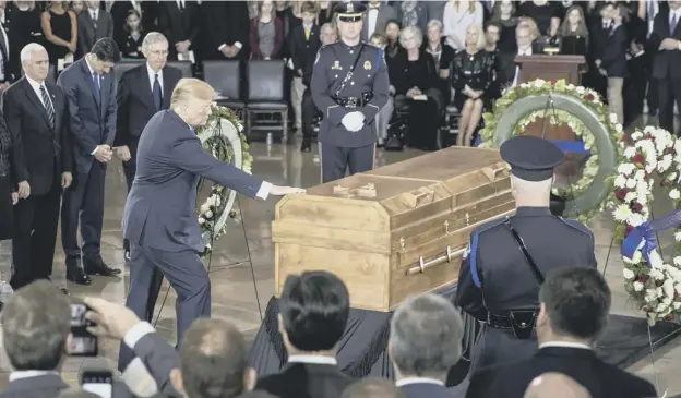  ?? PICTURE: J. SCOTT APPLEWHITE ?? 0 US President Donald Trump reaches out to touch the coffin of the Rev. Billy Graham as it lies in the Capitol Rotunda in Washington