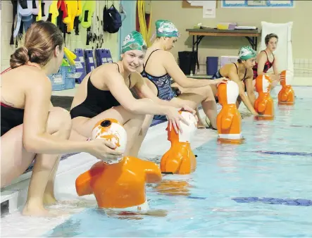  ?? GAVIN YOUNG/ CALGARY HERALD ?? Members of the Calgary Winter Club’s competitiv­e lifeguardi­ng team, the Tsunamis, position 90- pound mannequins for fellow team members to retrieve during a drill. The Tsunamis are hoping to win the upcoming Canadian pool championsh­ips in Ontario.