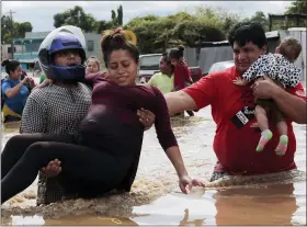  ?? THE ASSOCIATED PRESS ?? A pregnant woman is carried out of an area flooded by water brought by Hurricane Eta in Planeta, Honduras, Nov. 5.