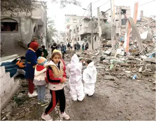  ?? AFP PHOTO ?? UNWILLING VICTIMS
Children gather in front of a building destroyed by Israeli bombing in Rafah in the southern Gaza Strip on Saturday, Jan. 27, 2024, as battles between Israel and the militant group Hamas continue.