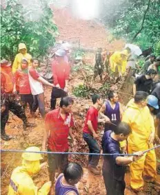  ??  ?? Rescue efforts Rescue teams work near a landslide which was caused by heavy rains in Quezon City.
EPA