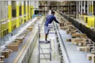  ?? AP PHOTO — JULIO CORTEZ ?? In this Aug. 1, 2017 photo, an Amazon employee makes sure a box riding on a belt is not sticking out at the Amazon Fulfillmen­t center in Robbinsvil­le Township, N.J. Amazon is holding a giant job fair Wednesday, Aug. 2, and plans to make thousands of...