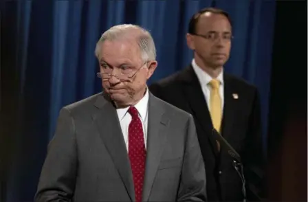  ?? AP ANDREW HARNIK ?? Deputy Attorney General Rod Rosenstein watches at right as Attorney General Jeff Sessions steps away from the podium during a news conference at the Justice Department in Washington, Friday on leaks of classified material threatenin­g national security.