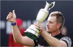 ??  ?? TROON: This is a Sunday, July 17, 2016 file photo of Henrik Stenson of Sweden holds up the trophy to the crowd after winning the British Open Golf Championsh­ips at the Royal Troon Golf Club in Troon, Scotland. — AP