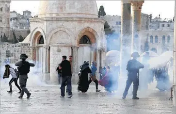  ?? Mahmoud Illean Associated Press ?? ISRAELI POLICE fire tear gas at Palestinia­n protesters at the Al Aqsa Mosque compound in Jersusalem. Israel removed recently installed metal detectors at the holy site, but the decision failed to quell the unrest.