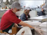  ?? ?? Diners at the Isabella Community Soup Kitchen got a styrofoam container with chicken, rice, peas and a roll during the first in-person meal since the start of the COVID-19 pandemic on Monday. The soup kitchen also provided drinks and a bag of cold food like fruit and pastries.