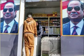  ?? AP PHOTO/AMR NABIL ?? A man buys groceries at a government sponsored shop decorated with with Egyptian President Abdel Fattah el-sissi posters in Cairo, Egypt, Sunday, Feb. 26, 2023. Annual inflation reached 26.5% in January, the highest in five years, and food prices in urban areas soared 48% last month, according to official figures. But the price increases consumers see in markets and grocery stores are much steeper.