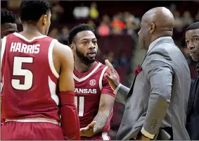  ?? AP/College Station Eagle/LAURA McKENZIE ?? Arkansas guard Keyshawn Embery-Simpson (11) and Jalen Harris (5) speak with Coach Mike Anderson as officials review a play in the first half Saturday against Texas A&amp;M in College Station, Texas.