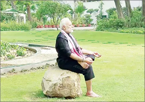  ??  ?? This screenshot taken from a video posted on India Prime Minister twitter handle, shows Indian Prime Minister Narendra Modi performing yoga following a fitness
challenge in New Delhi on June 13. (AFP)