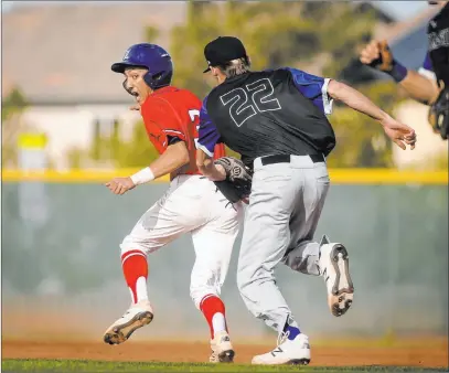  ?? Caroline Brehman Las Vegas Review-journal @carolinebr­ehman ?? Basic pitcher Shane Spencer (22) chases down Liberty baserunner Dylan San Nicolas in the fourth inning Tuesday at Liberty High School. Spencer was able to get his man both in the field and on the mound, firing a two-hitter in a 5-1 Wolves’ victory.