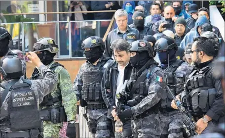  ?? AFP/Getty Images ?? DAMASO LOPEZ NUNEZ, the father of Damaso Lopez-Serrano, is led away by law enforcemen­t after his arrest in May in Mexico City. Lopez-Serrano now has pleaded guilty to drug distributi­on charges and also admitted to possessing guns for his cartel duties.