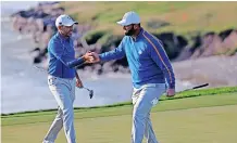  ?? MIKE SEGAR ?? TEAM Europe’s Jon Rahm and Sergio Garcia react on the 8th green after winning the hole during the Foursomes. | Reuters