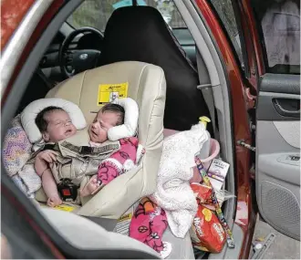  ?? Elizabeth Conley / Houston Chronicle ?? Carter and Callie Torres are strapped in to a custom-built car seat Friday as the family prepares to leave the Ronald McDonald House in Houston. The family uprooted their lives in Idaho six months ago to give the conjoined twins a chance for a healthy...