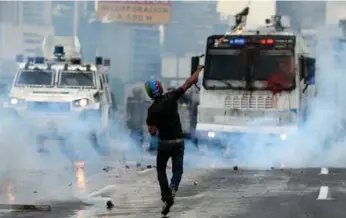  ?? FEDERICO PARRA/AFP/GETTY IMAGES ?? Venezuelan security forces appear determined to choke the protest movement with brute force, including tear gas.