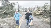  ?? JOHN SPINK — ATLANTA JOURNAL-CONSTITUTI­ON VIA AP ?? Two women make their way down a debris filled street in Coweta County, Ga. on Friday, after a tornado moved through the area.