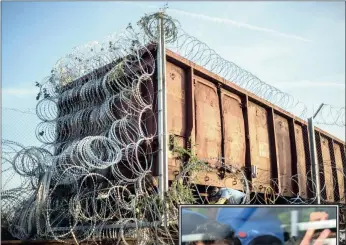  ?? PICTURES: AP ?? Razor wire is installed on a train truck being used as a border barrier between Hungary and Serbia near Roszke, 180km south-east of Budapest, yesterday.