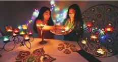  ?? Ahmed Kutty/Gulf News ?? Saasha Bhatkal and her sister Sarisha decorate their home in Abu Dhabi with scented candles and traditiona­l lighting.