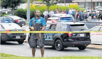  ?? MATT MCCLAIN/THE WASHINGTON POST ?? Authoritie­s respond to a deadly shooting Thursday afternoon at the Capital Gazette newspaper in Annapolis, Md. Police said the assailant lobbed smoke grenades and used a long gun in the attack.