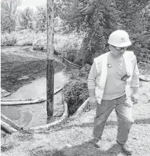  ?? Paul Sancya / Associated Press file ?? A worker monitors a creek in Marshall Township, Mich., after an oil leak in 2010.