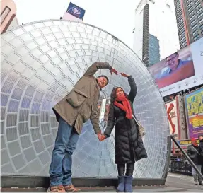  ??  ?? A couple from Tianjin, China, pose for a photo in front of “Window to the Heart,” a Valentine’s Day-themed art installati­on in Times Square. KATHY WILLENS/AP