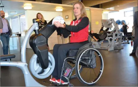  ?? ANDREA PEACOCK/The Daily Courier ?? Sonja Gaudet, a Paralympic wheelchair curler from Vernon, demonstrat­es an exercise machine designed for people with spinal cord injuries at the UBC Okanagan gym on Monday.