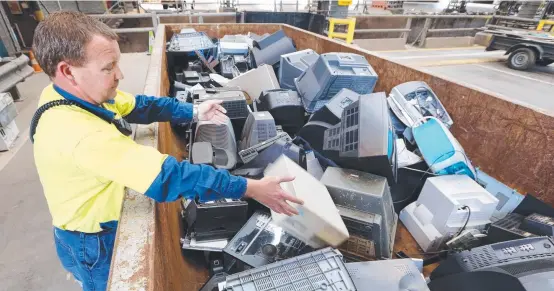  ?? USEFUL MATERIAL: Leading hand Shane Best sorts through a bin of e- waste, including discarded computers, at a Brisbane transfer station. Picture: Rob Maccoll ??