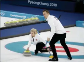  ?? NATACHA PISARENKO — THE ASSOCIATED PRESS FILE ?? In this file photo, Norway’s Kristin Skaslien, left, throws the stone as teammate Magnus Nedregotte­n looks on during the mixed doubles bronze medal curling match against Russian athletes Anastasia Bryzgalova and Alexander Krushelnit­sky at the...