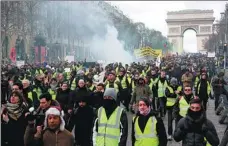  ?? ZAKARIA ABDELKAFI / AGENCE FRANCE-PRESSE ?? Protesters march during a demonstrat­ion near the Arc de Triomphe in Paris on Saturday.