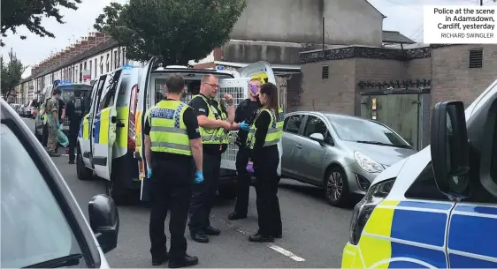  ?? RICHARD SWINGLER ?? Police at the scene in Adamsdown, Cardiff, yesterday