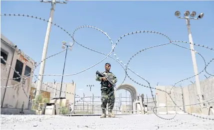  ??  ?? AWAITING ORDERS: An Afghan National Army soldier stands guard at the gate of Bagram US air base, on the day the last of American troops vacated it, Parwan province, Afghanista­n on Friday.