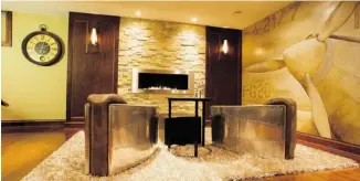  ??  ?? The Just Basements/Signature project went for a basement that has a transition­al/contempora­ry feel with elements such as custom cherry millwork, a linear fireplace and stone accents.