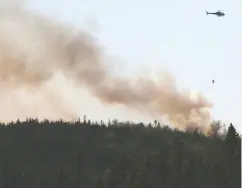  ?? Tim Krochak / The Cana dian Pres ?? Water is dropped on a wildfire near Porters Lake, N. S. on
Saturday after residents were asked to evacuate.