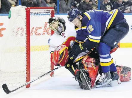  ?? CHRIS LEE/ ST. LOUIS POST- DISPATCH/ THE ASSOCIATED PRESS ?? St. Louis Blues’ Jori Lehtera, right, collides with Flames goaltender Jonas Hiller after scoring during the third period of an NHL hockey game on Thursday in St. Louis.